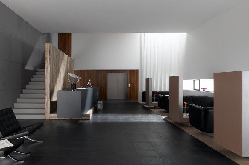 Hotelappartment Untergeschoss mit Holzmobiliar Hotelappartment Untergeschoss mit Holzmobiliar, dunklem Parkett und Treppenaufstieg